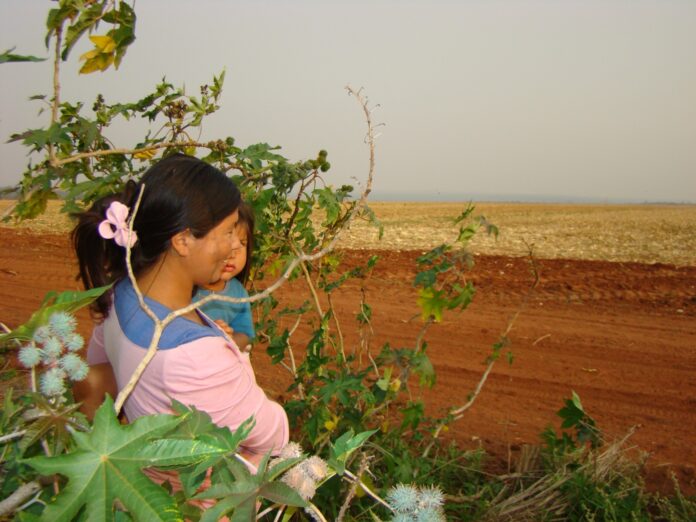 Una mujer con una niña en medio de una plantación en el interior del Paraguay
